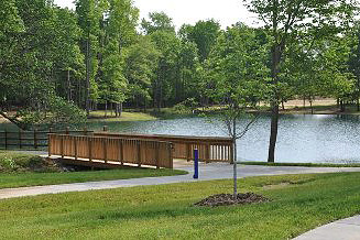 A lake with a walking bridge surrounded by grass
